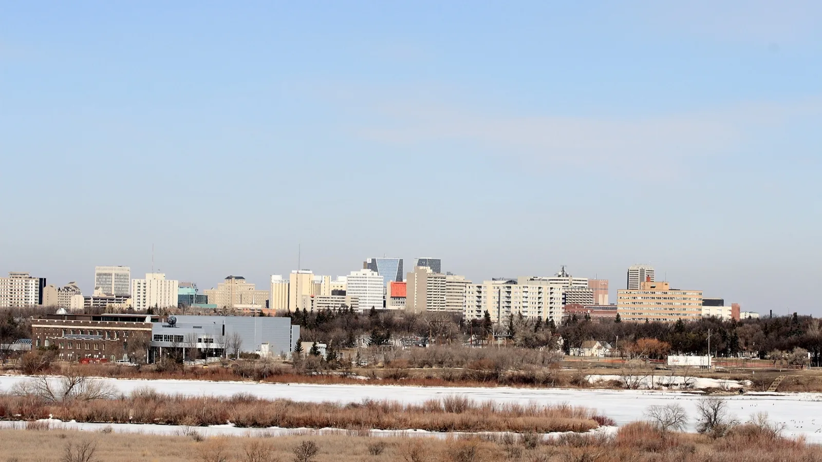 Regina's downtown skyline seen across Wascana Lake, with the Saskatchewan Science Centre in the foreground.